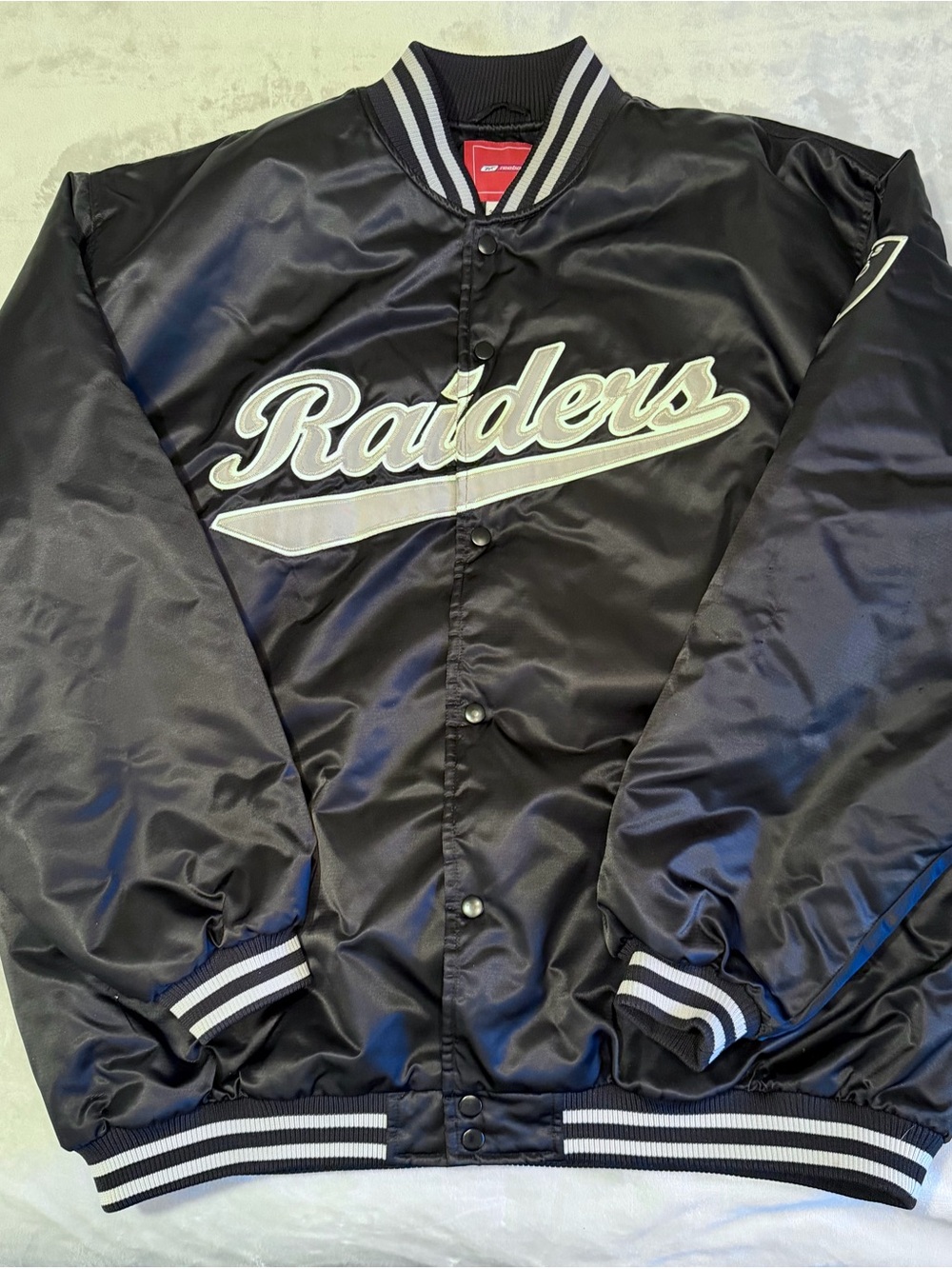 Reebok Raiders Satin Varsity Black Jacket with White Trim